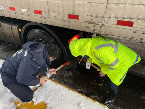 2.黄花收费站收费员为车辆清除底下冰雪.png